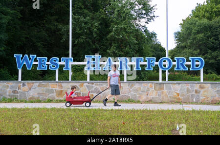 West Hartford, CT, Stati Uniti d'America. Sep 2019. Padre figlio di trazione su un carro giocattolo mentre passa attraverso le località di nuovo segno del gateway. Foto Stock