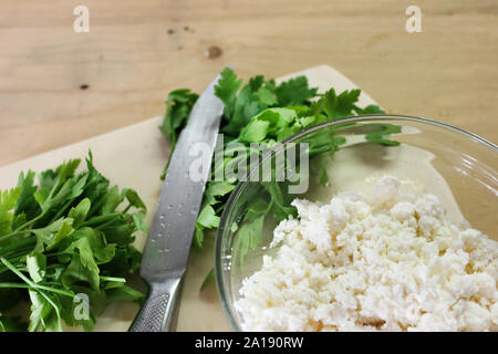 Prezzemolo fresco con il coltello sul tagliere di legno Foto Stock