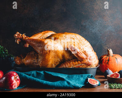 Arrosto di tacchino intero su un tavolo con Apple, la zucca e le figure per la famiglia per la Festa del Ringraziamento. Foto Stock