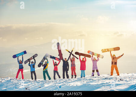 Grande gruppo di amici felici gli sciatori e gli snowboarder divertendosi e azienda di sci e snowboard sulla cima della montagna Foto Stock