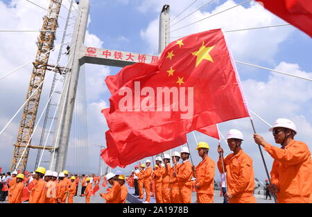 (190925) -- FUZHOU, Sett. 25, 2019 (Xinhua) -- lavoratori assistere ad una cerimonia che segna il completamento della struttura principale del Pingtan stretto Road-ponte ferroviario nel sud-est della Cina di provincia del Fujian, Sett. 25, 2019. Cina mercoledì completato la struttura principale della più lunga del mondo cross-sea road-ponte ferroviario nel Fujian. L'ultima trave di acciaio, del peso di 473 tonnellate, è stato avvitato sullo stretto di Pingtan Road-rail Bridge, un altro mega progetto in Cina, mercoledì mattina. Con una sconcertante span di 16.34 km, il ponte collega Pingtan Isola e quattro isolette vicine alla terraferma di Fujian provi Foto Stock