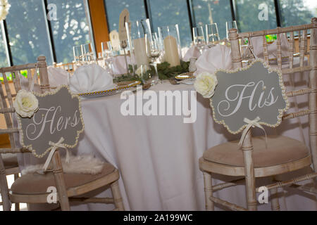 Matrimonio di lusso reception Tavolo da pranzo setup con rami di eucalipto e oro decorazione geometrica su un rustico con sedie in legno Foto Stock