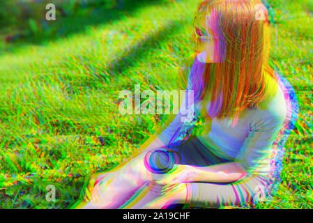 Effetto di glitch. Giovane bella ragazza di bere il caffè nel parco seduto sull'erba. Copia banner space Foto Stock