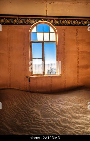 Stanza vuota con una finestra e la sabbia in le rovine di una città fantasma Kolmanskop, Namibia Foto Stock