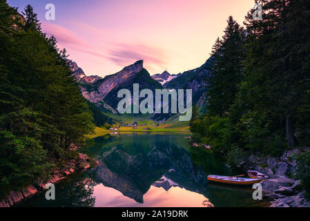 Tramonto sul lago Seealpsee con piccole imbarcazioni nelle alpi svizzere, Svizzera Foto Stock