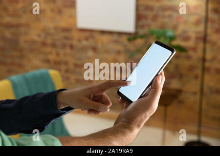 Coppia giovane di casa utilizzando uno smartphone Foto Stock