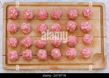 Materie le polpette di carne di maiale iberico sul tagliere preparate per la cottura Foto Stock