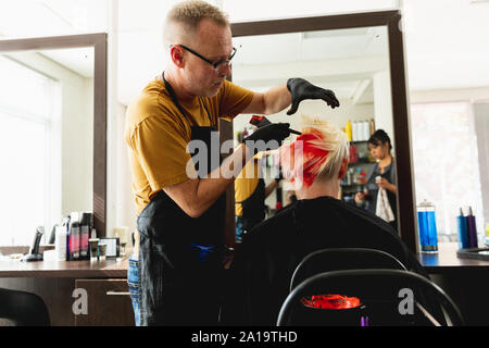 Parrucchiere maschio e femmina in client parrucchiere Foto Stock