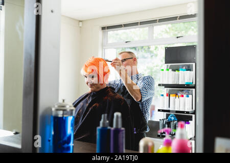 Parrucchiere maschio e femmina in client parrucchiere Foto Stock