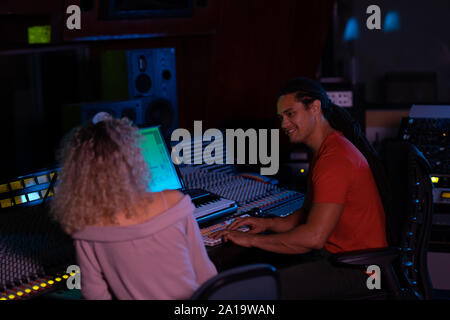 Maschio e femmina produttori musicali lavorando insieme in un sound studio Foto Stock