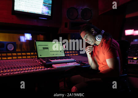 Maschio produttore musicale lavorando in un sound studio Foto Stock