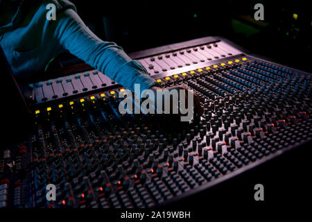 Maschio produttore musicale il lavoro presso il banco di miscelazione in un sound studio Foto Stock