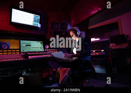 Femmina produttore musicale lavorando in un sound studio Foto Stock