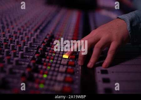 Maschio produttore musicale il lavoro presso il banco di miscelazione in un sound studio Foto Stock