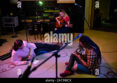 Gruppo scrittura in un sound studio Foto Stock