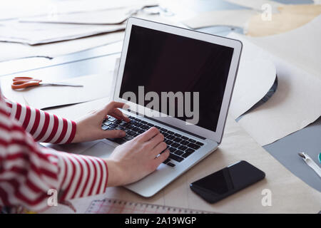 Studentessa utilizzando il portatile in un collegio di moda Foto Stock