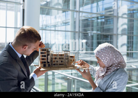 Maschio e femmina architetti discutendo su progetto di costruzione in office Foto Stock