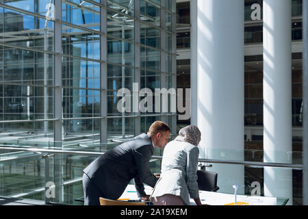 Maschio e femmina architetti discutendo su blueprint in office Foto Stock