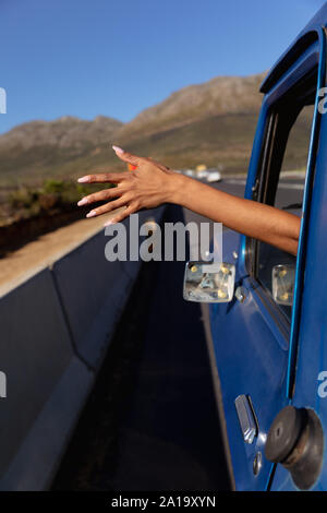 Giovane donna inceppato il suo braccio fuori del pick-up su autostrada Foto Stock