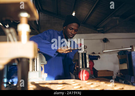 Giovane uomo che lavora in un equipaggiamento sportivo factory Foto Stock