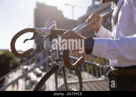 Giovani professionisti uomo che porta una bici Foto Stock