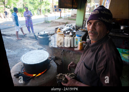 Uomo indiano la preparazione di cibo in un tipico cibo di strada in stallo Rudraprayag town, Uttarakhand, India Foto Stock