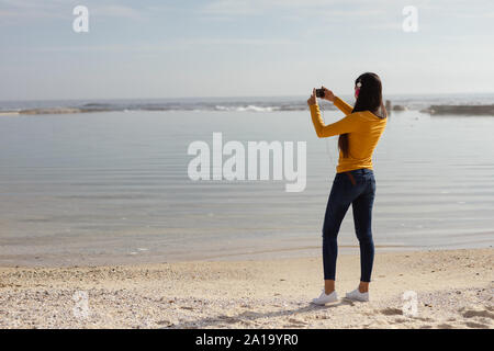 Giovane donna ascoltare musica e scattare foto Foto Stock