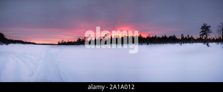 Tramonto sul lago ghiacciato intorno Kaamanen, Arctic Finlandia Foto Stock