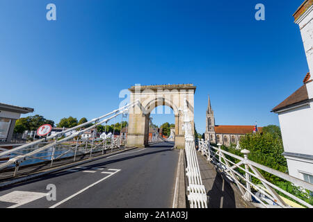 La torre sud ingresso arco di Marlow sospensione ponte sopra il fiume Tamigi, Marlow, Buckinghamshire, Inghilterra del sud-est e la Chiesa di Tutti i Santi Foto Stock