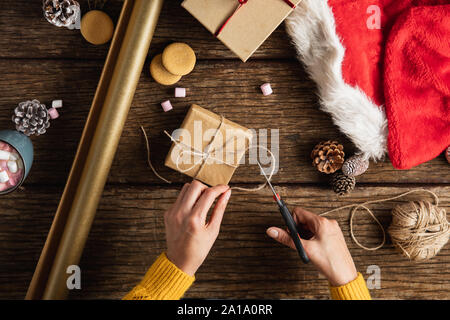 Le mani di incarto regali di natale Foto Stock