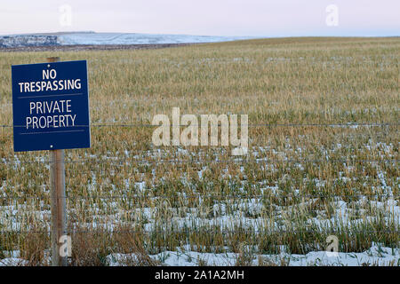 Un No la trasgressione, la proprietà privata segno postato su terreni agricoli che è proprio sul bordo della città di sviluppo nel nord est di Calgary. Foto Stock