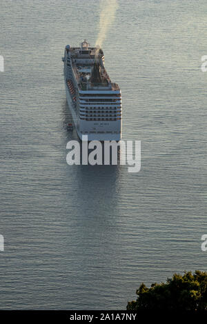 SARANDA, ALBANIA - Giugno 6, 2019: grande nave da crociera MSC Musica è ancorata nella baia di fronte alla piccola città albanesi. Serata primaverile vista dalla ca Foto Stock