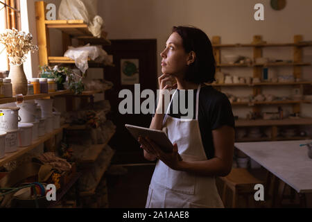 Potter femmina utilizzando compressa in un studio in ceramica