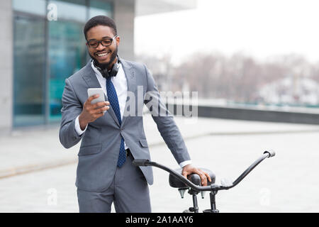 Felice imprenditore texting sul telefono vicino a noleggio Foto Stock