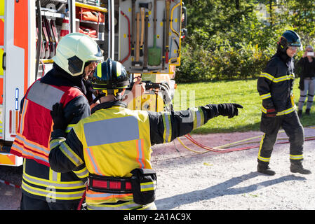 Vigili del fuoco consultare sulla scena dell'incidente come loro guideranno il salvataggio. Sullo sfondo di un uomo è la registrazione con il suo telefono cellulare. Foto Stock