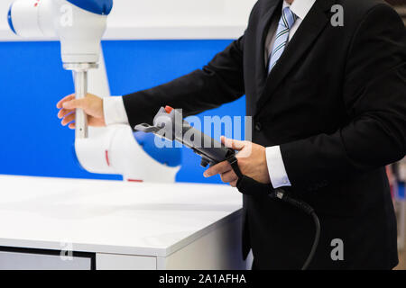 Il tecnico dimostra il lavoro del robot-collaboratore Foto Stock