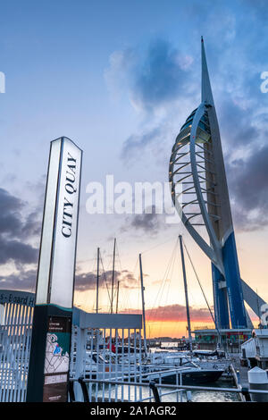 Portsmouth, Hampshire, Inghilterra. Dopo una calda ed umida giornata di Hampshire costa, le luci si accendono al Gunwharf Quays come il sole tramonta su Portsmouth Foto Stock