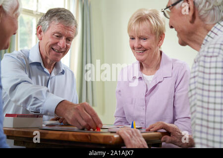 Gruppo di pensionati amici giocare gioco di bordo al Social Club Foto Stock