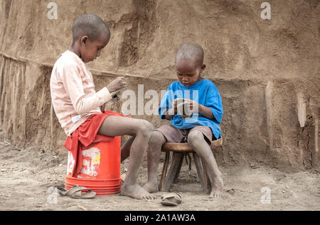 Arusha, Tanzania, 10 Settembre 2019: Maasai i bambini a giocare con le loro scarpe Foto Stock