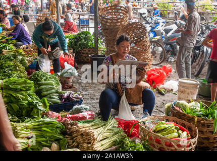 Le donne per la vendita di frutta e verdura al Pasar Badung mercato di Denpasar, Bali, Indonesia Foto Stock