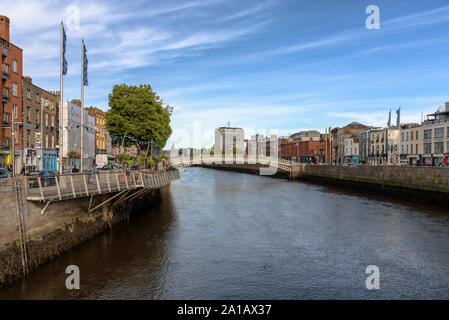 Il Liffey Boardwalk e la Ha'penny Bridge sul fiume Liffey nel centro di Dublino, Irlanda su una soleggiata giornata estiva Foto Stock