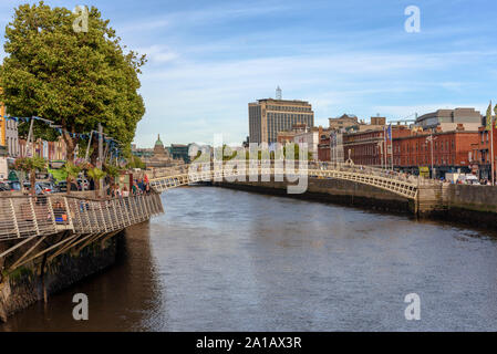 Il Liffey Boardwalk e la Ha'penny Bridge sul fiume Liffey nel centro di Dublino, Irlanda su una soleggiata giornata estiva Foto Stock