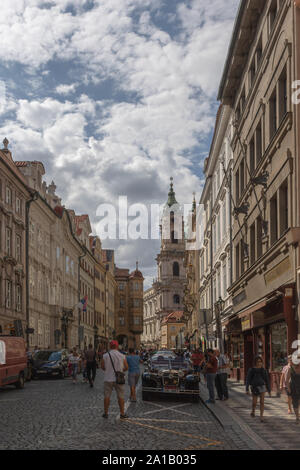 Mostecká street in direzione Malostranské náměstí e la chiesa di San Nicola a Praga, Repubblica Ceca. Foto Stock