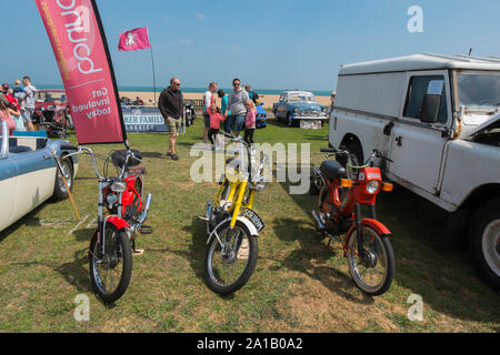 Anni Settanta Puch e Tomos ciclomotori accanto a uno degli anni cinquanta Austin Healey Mkll 3000 e un Land Rover presso la trattativa Classic Motor Show il Walmer verde da spiaggia, Dea Foto Stock