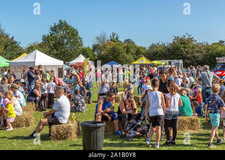 Adulti e bambini godono le condizioni meteorologiche a Belbroughton ricreazione centro campo circondato da bancarelle di cibo locale e produttori artigianali. Foto Stock