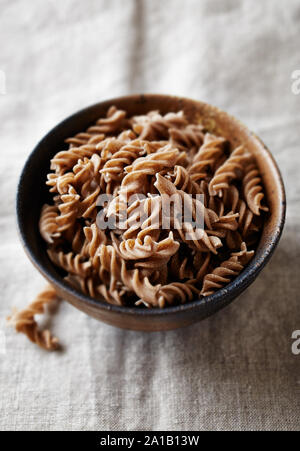 Cereali integrali pasta di farro in una ciotola di ceramica (pasta biologica) Foto Stock