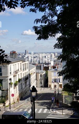 Guardando ad est verso il basso rue du Chevalier de la Barre con persone di andare sulla vita quotidiana nel villaggio di Montmartre, Paris, Francia. Foto Stock