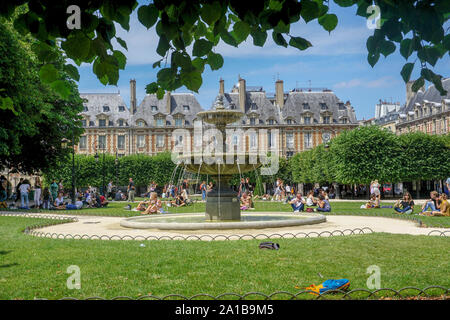 'Un fresco luogo ombroso' cattura di Place des Vosges da sotto la fresca ombra di uno degli alberi durante una calda giornata estiva mentre esplorare questa piazza. Foto Stock