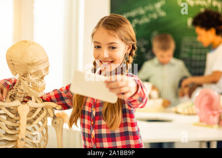 Gentile ragazza che abbraccia il suo nuovo scheletro artificiale Foto Stock