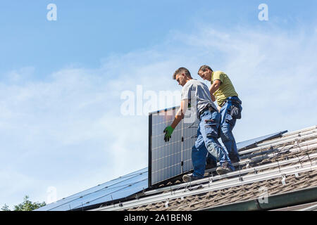 Installazione solare pannello fotovoltaico sistema. Pannello solare tecnico installazione di pannelli solari sul tetto. L'energia alternativa concetto ecologico. Foto Stock